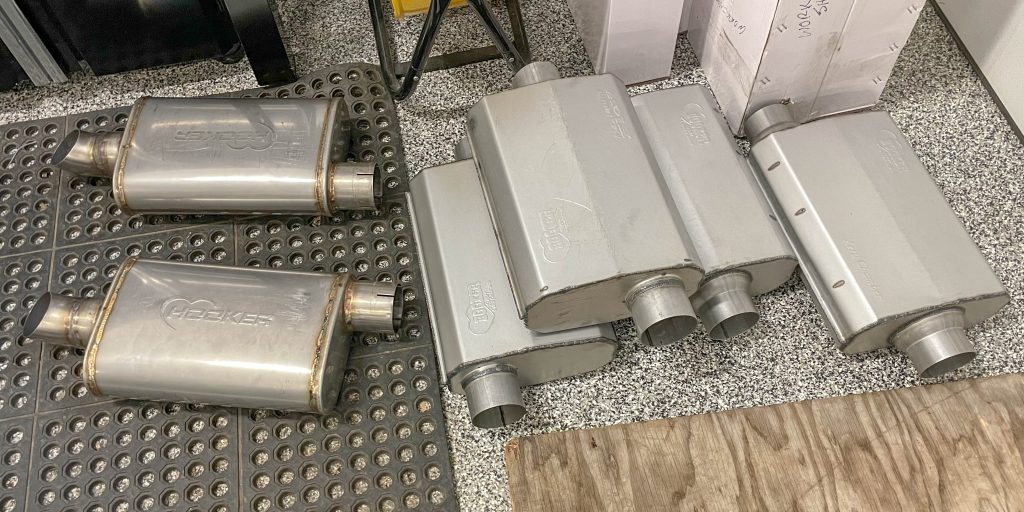 a collection of mufflers on a shop floor