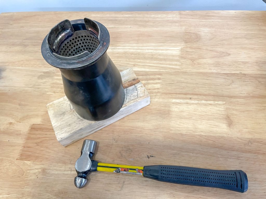 hammering in a perforated cone into a muffler tip