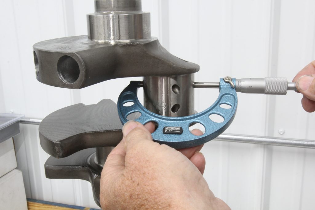 using a micrometer on an engine crankshaft