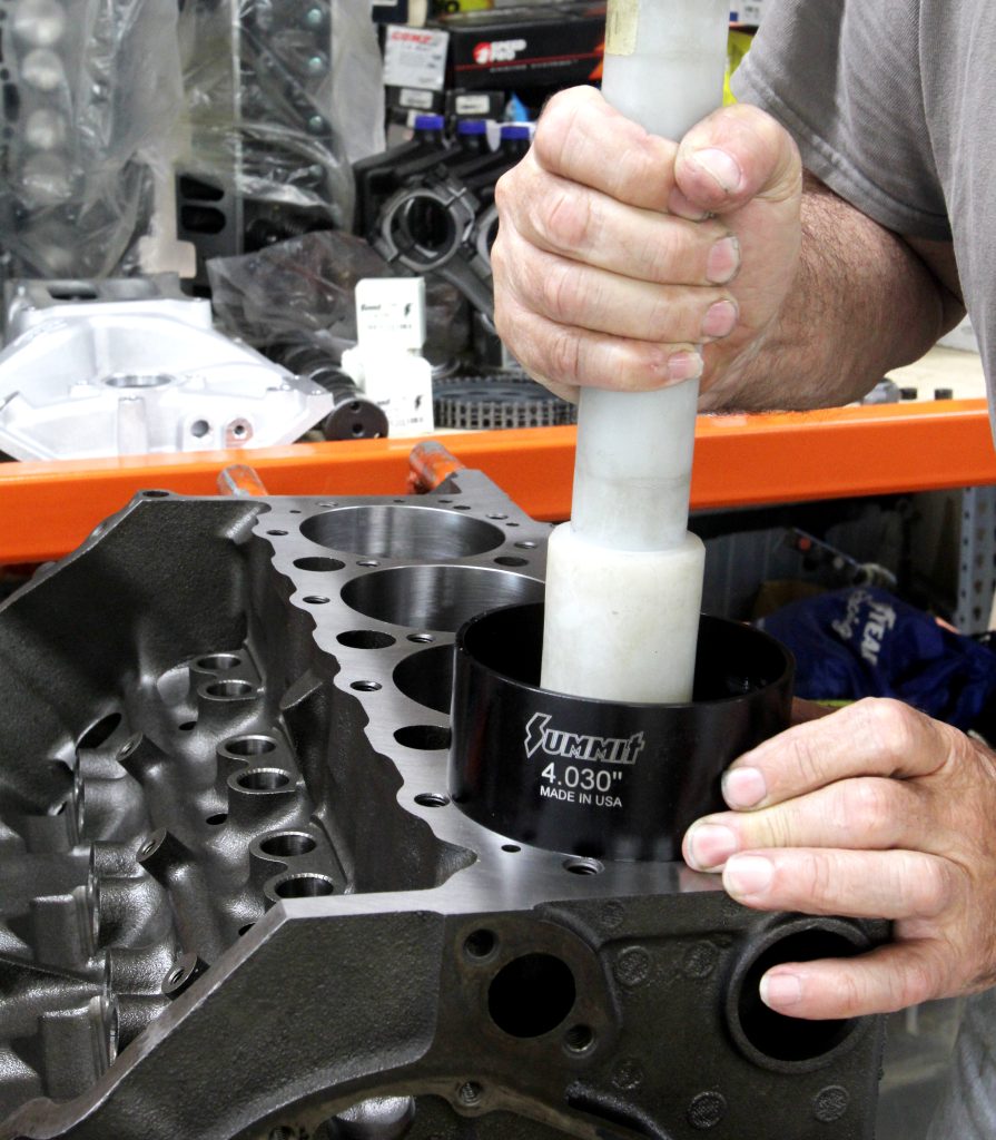 hammering in pistons in a cylinder block