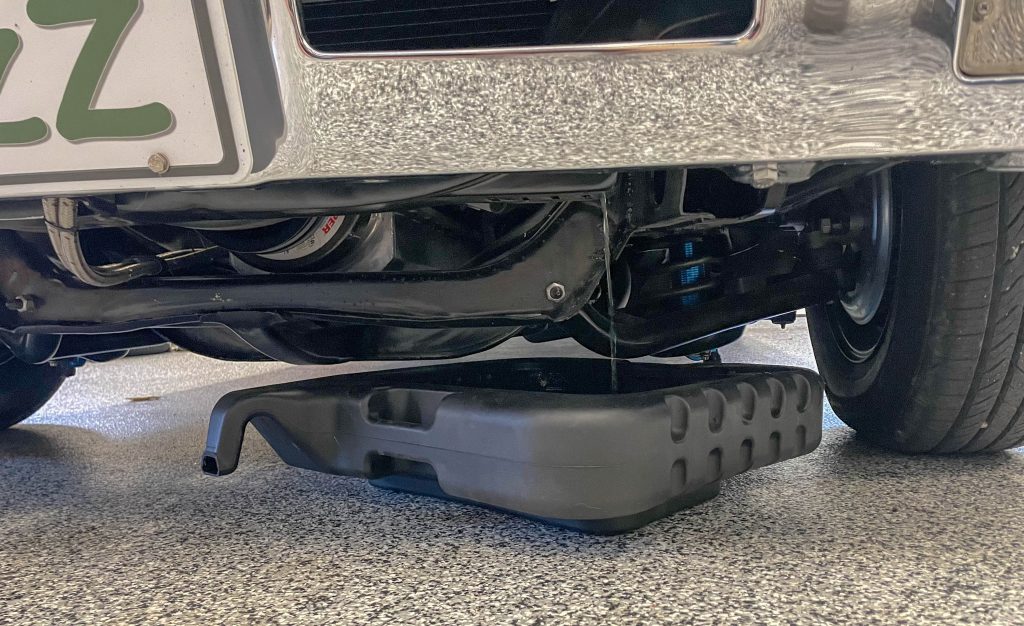 coolant draining out of an old car into a pan