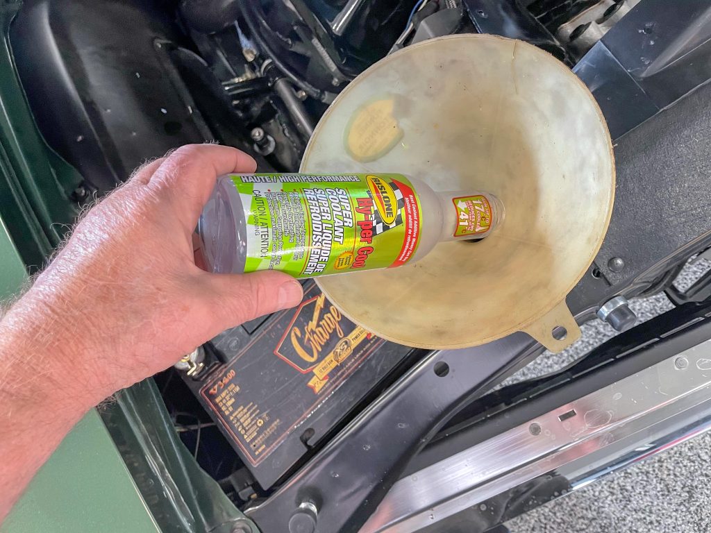 pouring radiator coolant flush into a funnel