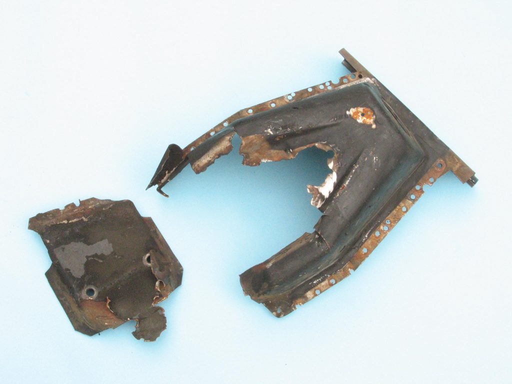 a rusted, broken mustang shock tower