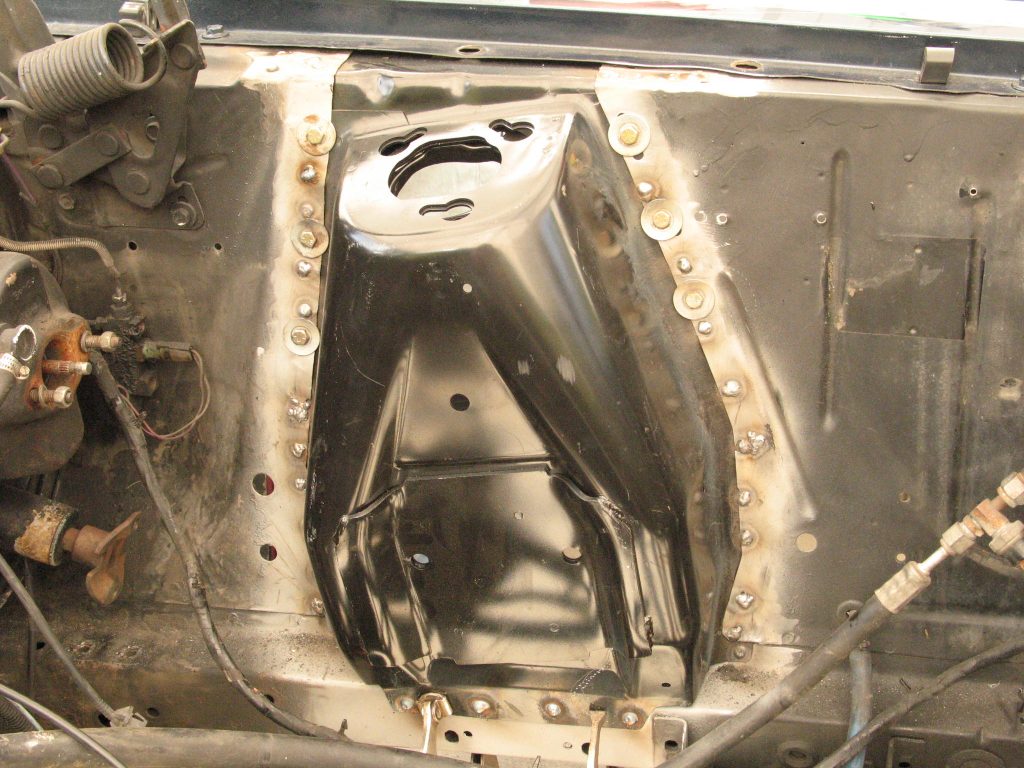 shock tower getting welded into a vintage ford mustang