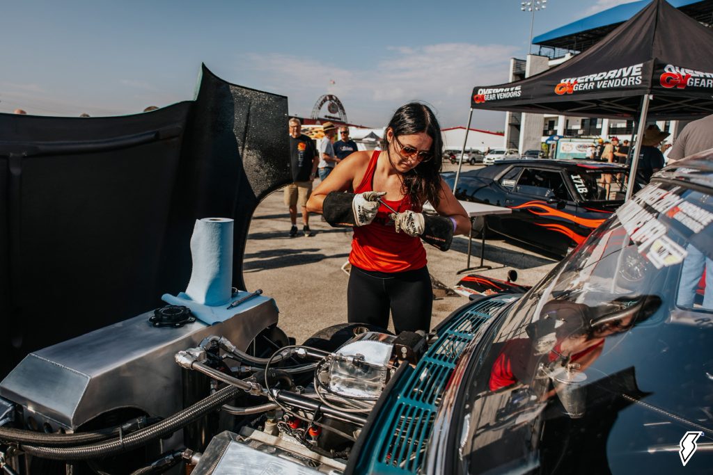 alex taylor working on the engine of her 1955 chevy