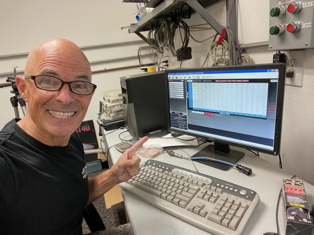 man posing next to a computer screen