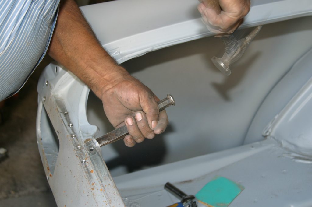using a chisel to separate vintage car metal panels