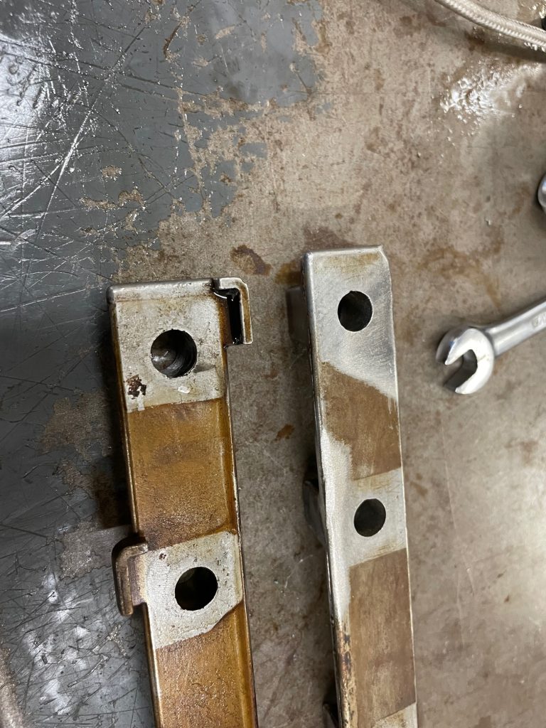 a pair of metal brackets on workbench