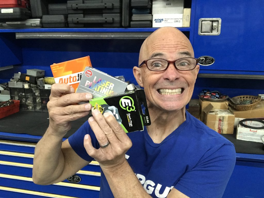 man holding packages of spark plugs