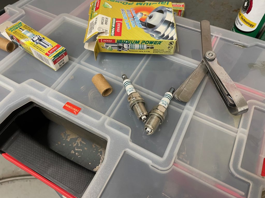 spark plugs and feeler gauge on a table