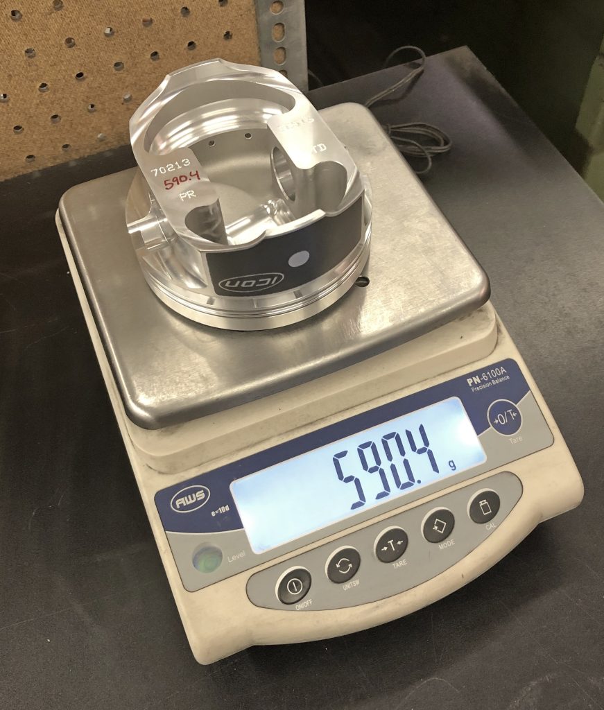 weighing a piston head on a scale