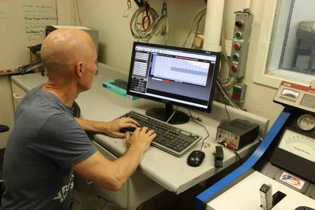 man at computer tuning an engine