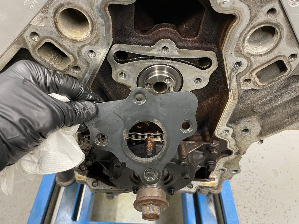 man holding cam plate near ls engine
