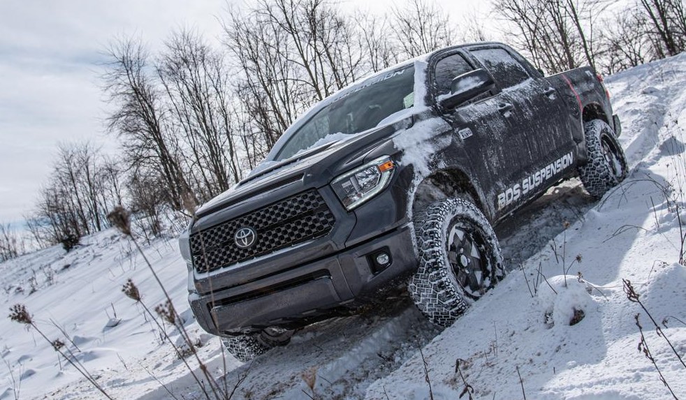 toyota tundra truck descending a snowy trail hill