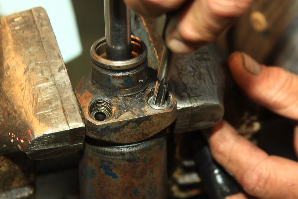 removing fitting cap from a hydraulic cylinder