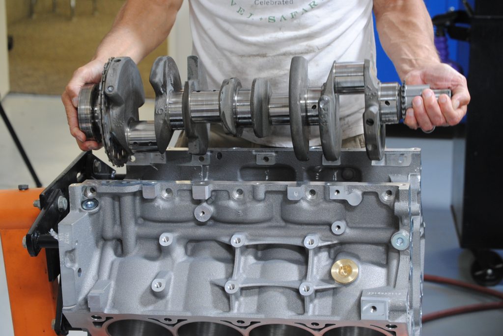 man dropping crankshaft into a v8 engine