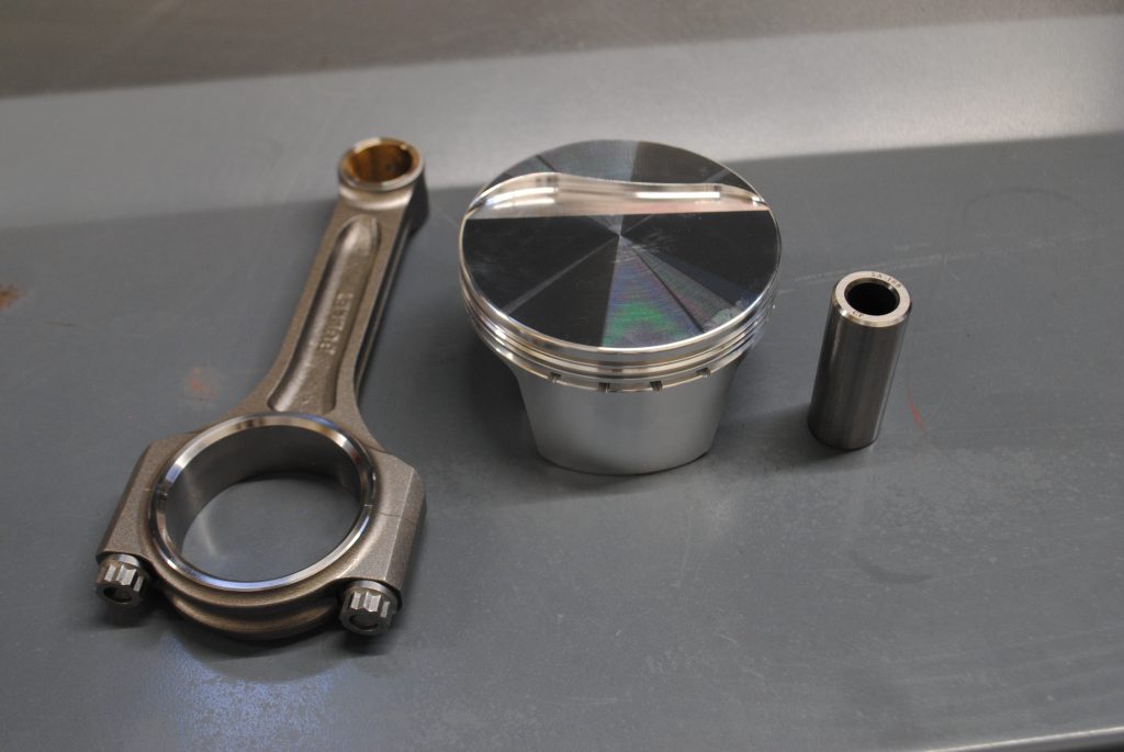 connecting rod, piston & wrist pin on table