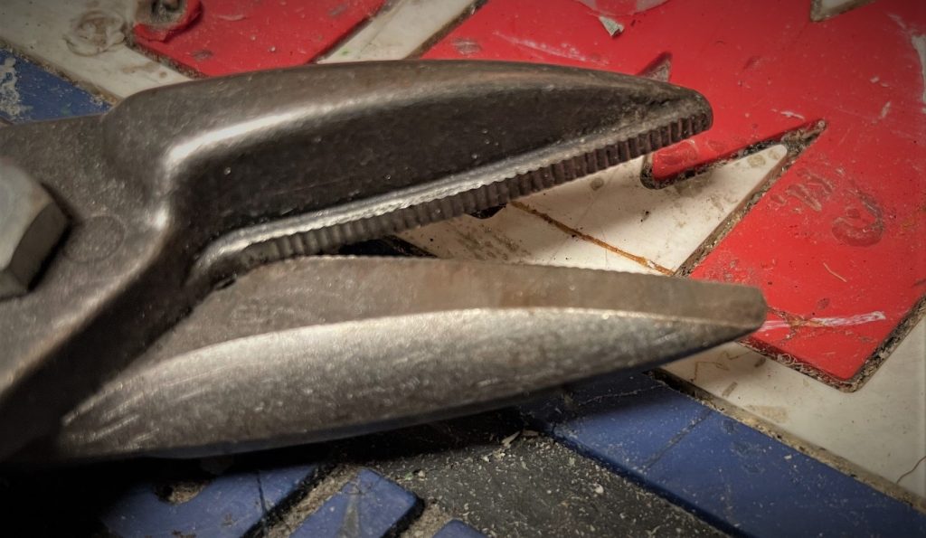 close up of serrated teeth on a tin snip