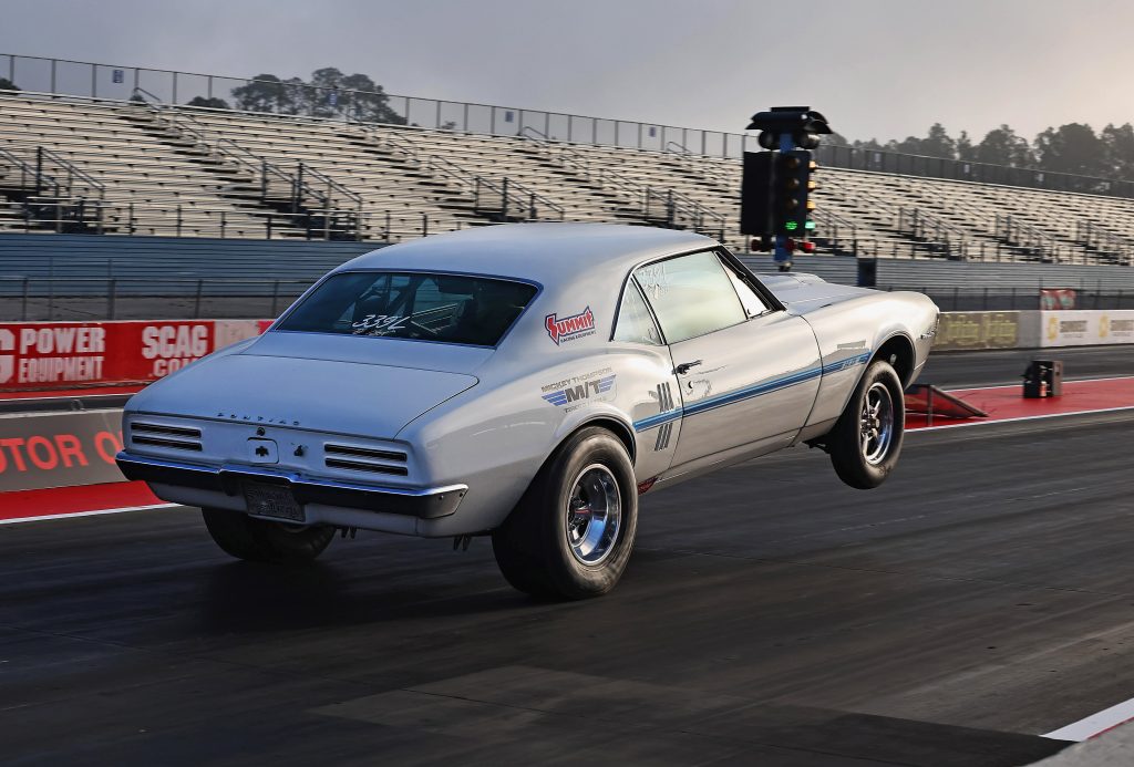 rear view of a pontiac firebird launching at dragstrip