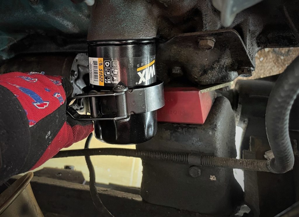man using oil filter wrench on an AMC 258