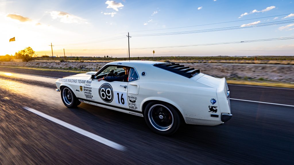 Vintage Ford Mustang fastback race car on highway